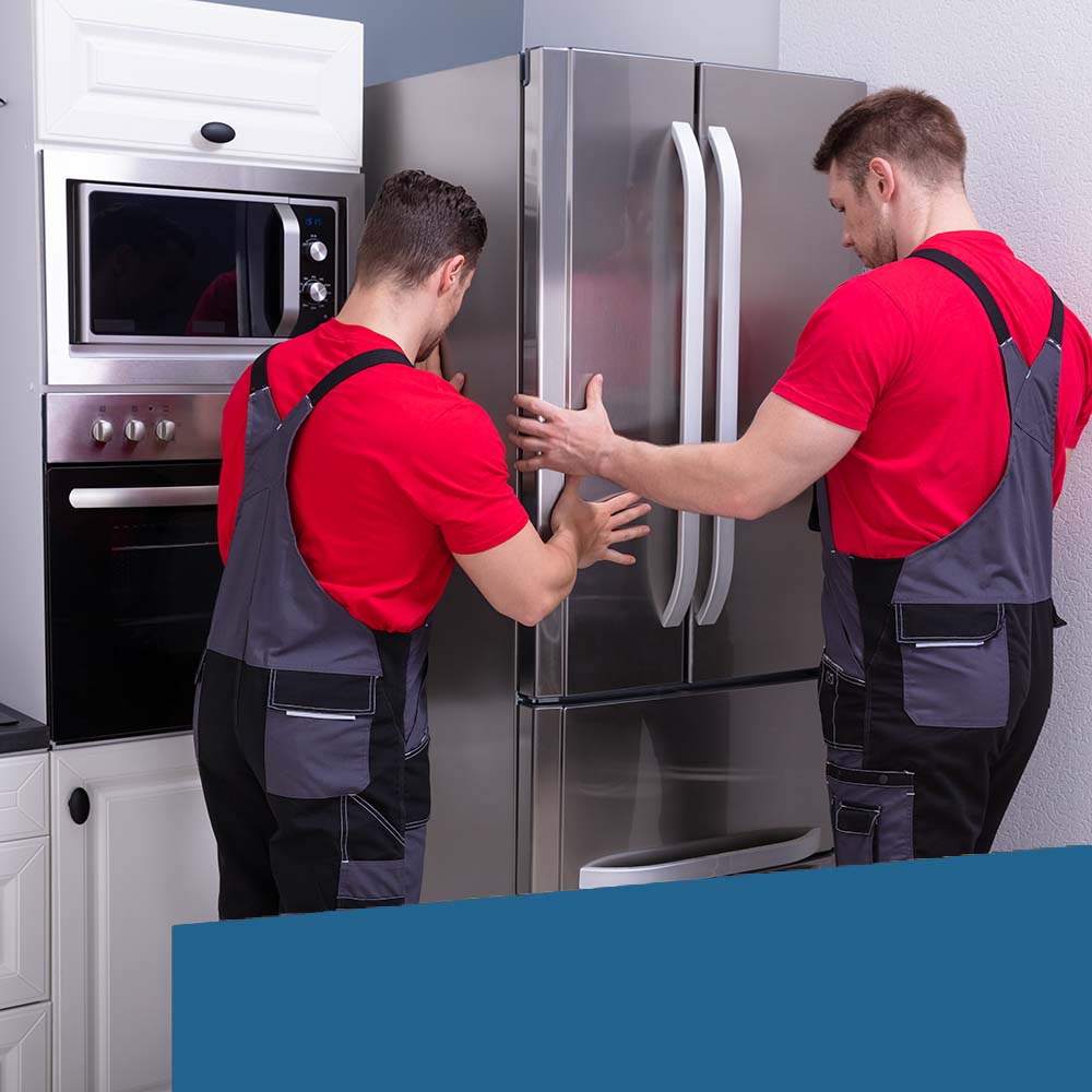 Zwei Handwerker installieren einen großen Kühlschrank